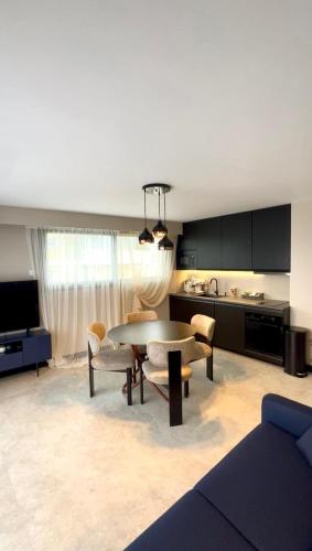 a living room with a table and a kitchen at Appartement cosy proche de la Croisette et du Palais des Festivals in Cannes