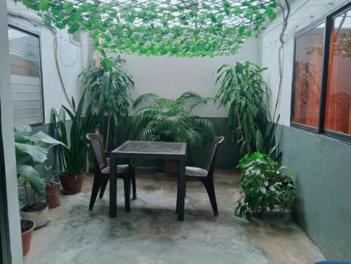 a table and chairs in a room with plants at Casa Hotel El Eden in Carepa