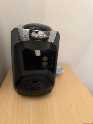 a black toaster sitting on top of a wooden table at London Cozy Room, Fast WiFi in London