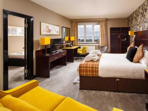a hotel room with a bed and a living room at Mercure Ayr Hotel in Ayr