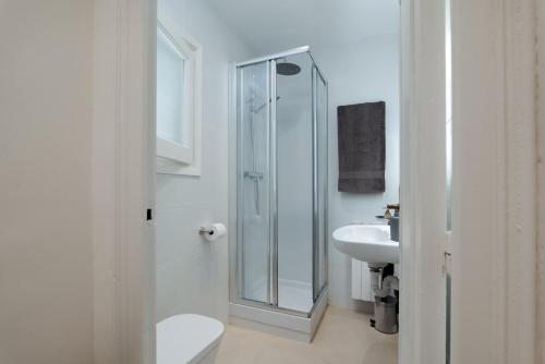 een badkamer met een douche, een toilet en een wastafel bij Apartamento Rosari II in Vilassar de Mar