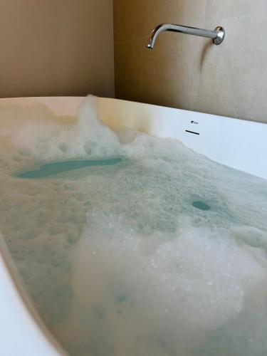 a bath tub filled with water with a faucet at Recanto Gamboa in Garopaba