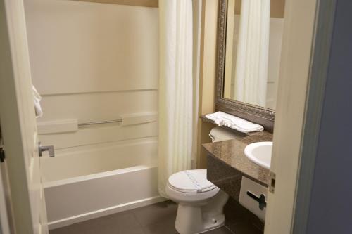 a bathroom with a toilet and a sink and a mirror at Ocean Paradise Hotel & Resort in Ocean Shores