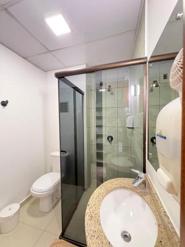 a bathroom with a sink and a glass shower at Hotel Boa Vista - 200mts do Shopping Pátio in Chapecó