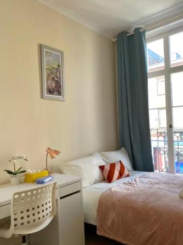 a bedroom with a bed and a desk and a window at Lovely Rooms in Camden Town, Central London in London