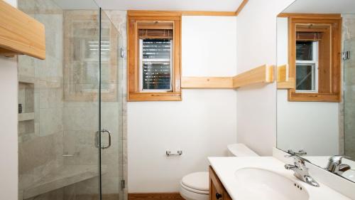 a bathroom with a toilet and a glass shower at Raven by AvantStay Entertainers Dream w Pool Hot Tub Game Room 9 BRs in Sullivans Island