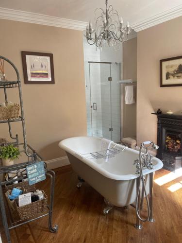 a bath tub in a bathroom with a chandelier at Wayside , 3 bed , 2 bath charming house close to Lincoln in Lincoln