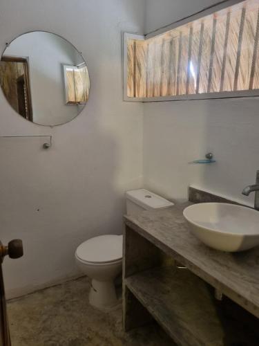 a bathroom with a sink and a toilet and a mirror at Hostal nido tortuga in San Antero