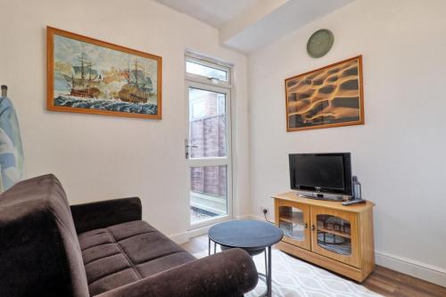 a living room with a couch and a tv at Ivy on Sea Villa in Southend-on-Sea