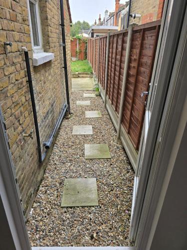a walkway between two buildings with a door open at Ivy on Sea Villa in Southend-on-Sea