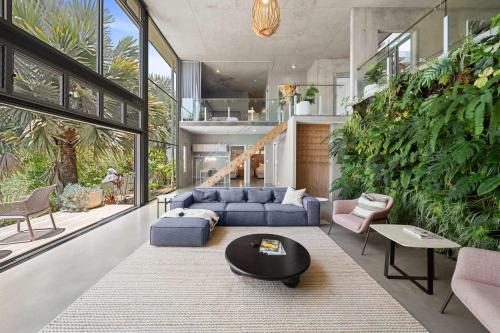 Una sala de estar con un sofá azul y una mesa. en The Opal at Coolum - Mountain and Ocean Views, en Yaroomba