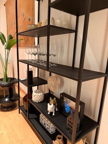 a black shelf with glasses and other items on it at Het huis van Hermens in Meerssen