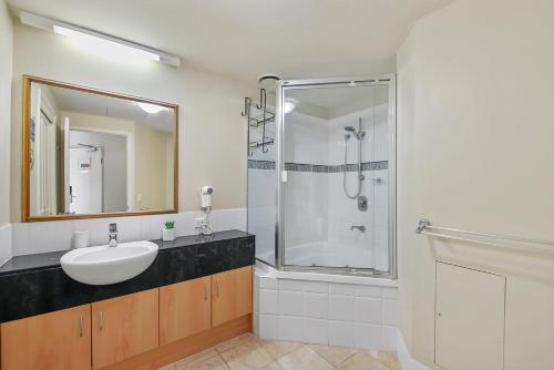 a bathroom with a sink and a shower at Landmark 1 Bedroom Beachside Escape in Mooloolaba