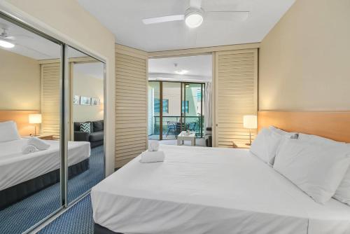a bedroom with two beds and a mirror at Landmark 1 Bedroom Beachside Escape in Mooloolaba