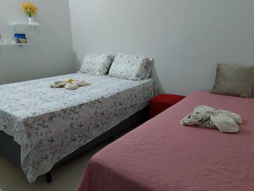 a bedroom with two beds with towels on them at hospedaria Cantinho da Rosa in Santo Amaro