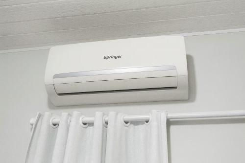 a air conditioner on a wall above a curtain at ꕥ Suíte Deluxe Privativa ꕥ Cantinho da Margarida ꕥ Hospedagem & Hostel Premium in Belém