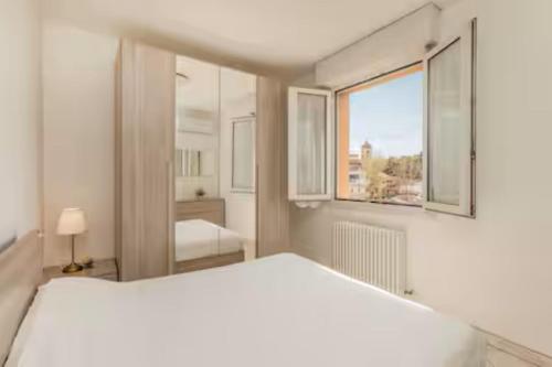 a white bedroom with a large bed and a window at Patty Sweet Home, Cattolica Centro in Cattolica