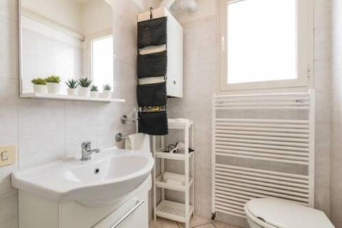 a white bathroom with a sink and a toilet at Patty Sweet Home, Cattolica Centro in Cattolica