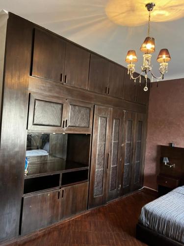 a large wooden cabinet in a bedroom with a bed at Magnifique appartement villa in Martil