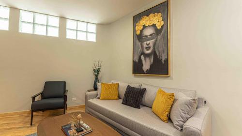 a living room with a couch and a painting on the wall at Apartamentos Ejecutivos, Lujo y Confort en el corazon de Polanco in Mexico City