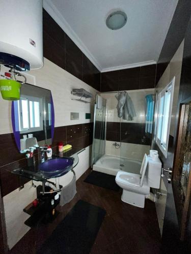 a bathroom with a shower and a toilet and a sink at Magnifique appartement villa in Martil