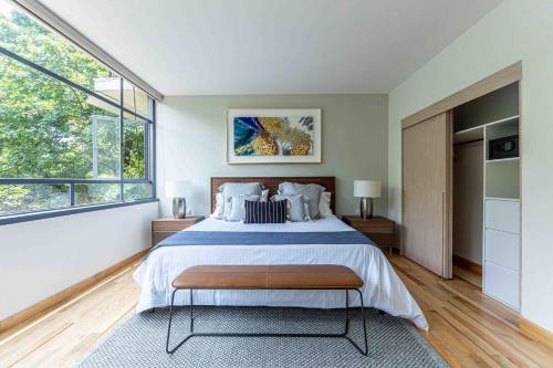 a bedroom with a large bed and a large window at Apartamentos Ejecutivos, Lujo y Confort en el corazon de Polanco in Mexico City