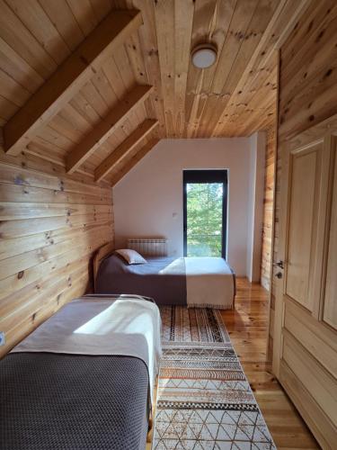 two beds in a room with wooden ceilings at Villa Jelterra in Uskoci
