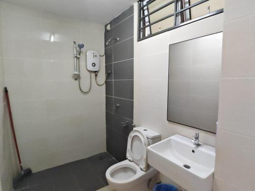 a bathroom with a toilet and a sink and a mirror at De Centrum Residences in Kajang