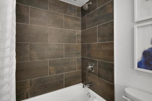 a bathroom with a brown tiled wall at World of Blue 711 I Beautiful King Hotel Room in Secaucus