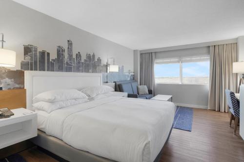 a white bedroom with a large bed and a desk at World of Blue 711 I Beautiful King Hotel Room in Secaucus