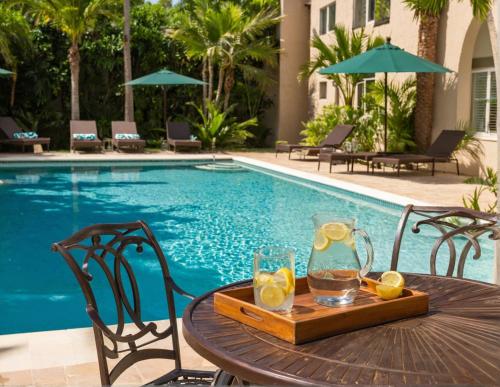 a table with a tray of lemonade on it next to a pool at Resort-Style Family Getaway in Santa Monica in Los Angeles