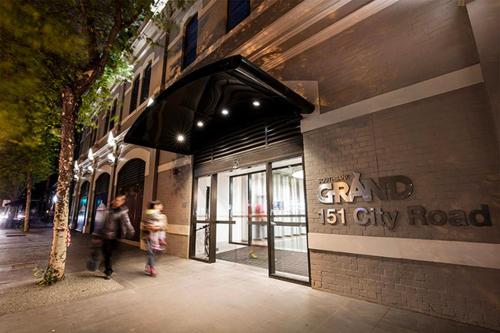 a man and woman walking down a sidewalk outside a building at Balcony, Free Parking, Workspace, Shared Pool & Gym in Melbourne