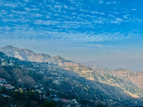a view of a valley with mountains and houses at Askari Lodges Murree in Murree