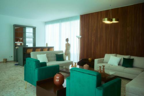 a living room with blue furniture and a woman standing in the window at Casa Orbit AC Pool Jacuzzi Central Location in Oaxaca City