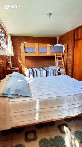 a bedroom with a large bed with two bunk beds at Casa Montemira in Ica