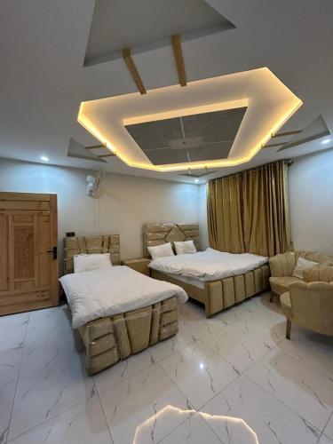 a bedroom with two beds and a couch and a ceiling at Askari Lodges Murree in Murree