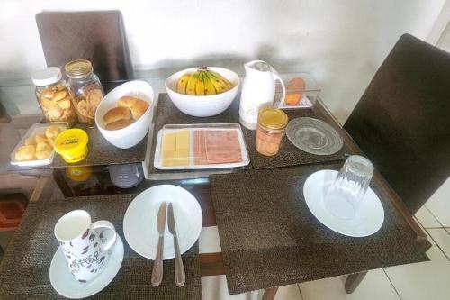 een tafel met witte borden en keukengerei erop bij ꕥ Casa Premium com 9 Lugares ꕥ Cantinho da Margarida ꕥ Hospedagem & Hostel Premium in Belém