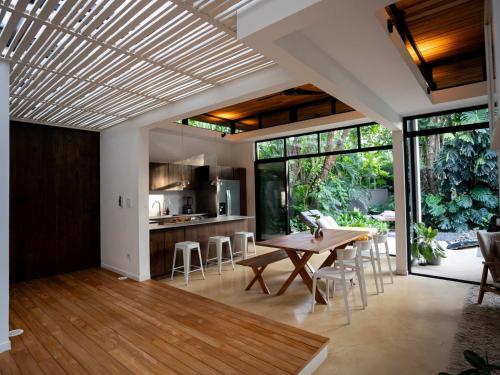 a dining room and kitchen with a table and chairs at Nalu Nosara Pool Villa Sombra in Nosara