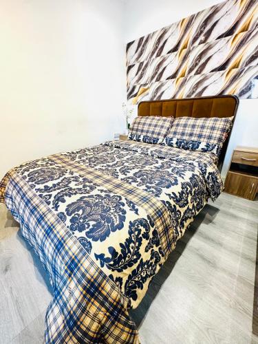 a bedroom with a bed with a blue and white blanket at Enjoy the comfort at private room en-suite with free Parking - near Luton airport in Luton