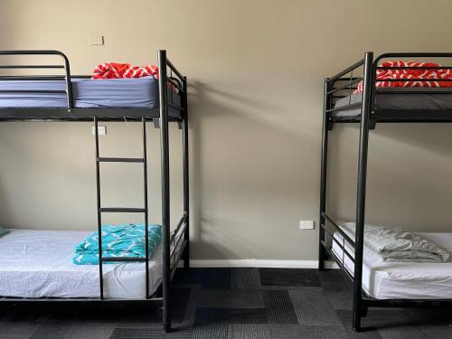 a room with three bunk beds in a room at sj hostel in Legana