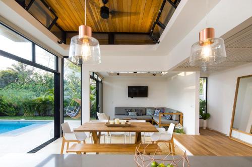 a dining room with a table and chairs and a pool at Nalu Nosara Pool Villa Jardin in Nosara