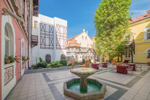 a courtyard with a fountain in the middle of a building at Aparthotel Tři lilie in Františkovy Lázně