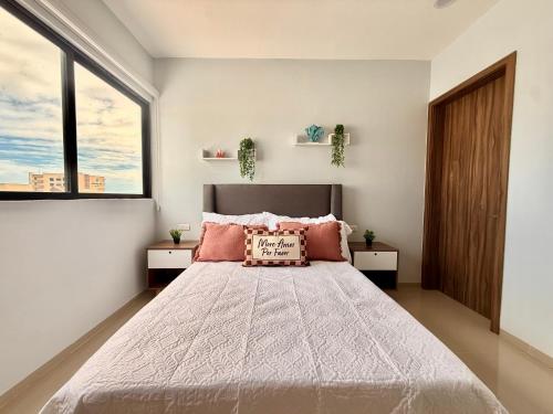 Un dormitorio con una cama grande con dos ventanas. en Departamento Boca del Rio Costa de Oro, 