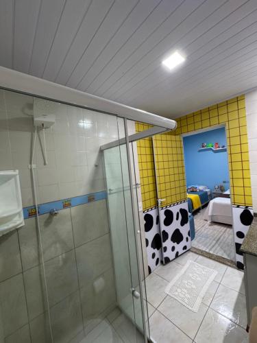 a bathroom with a shower with a glass door at Suíte Toy Story - Pousasa Castelo do Luar in Penha