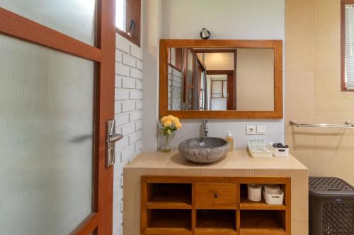 a bathroom with a sink and a mirror at Umah Adenium Ubud in Tegalalang