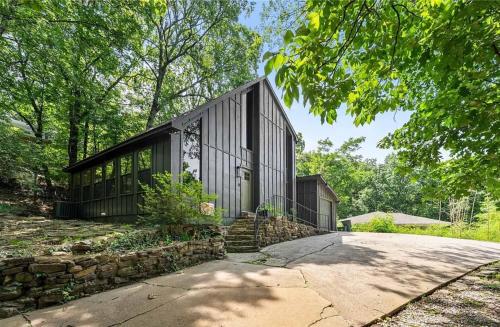 a black house with a stone wall at Fayetteville Getaway - Near Campus and Dickson in Fayetteville