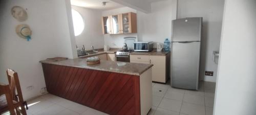 een keuken met een koelkast en een aanrechtblad bij Departamento en Playa Pulpos - 2 habitaciones - Piscina compartida in Arica