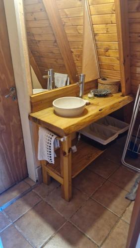 Cabañas Mateo في فيلا بيهوينيا: طاولة حمام مع حوض ومرآة