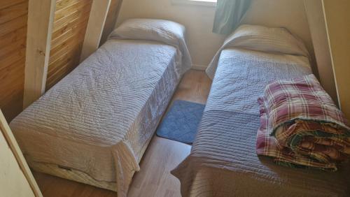 Cabañas Mateo في فيلا بيهوينيا: سريرين توأم في غرفة صغيرة ذات أرضية خشبية