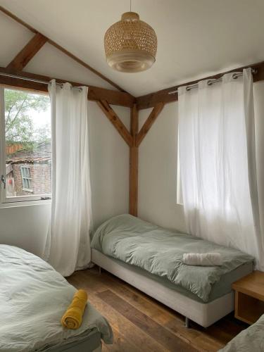 Un dormitorio con dos camas y una ventana. en Milan Farm Chalet cozy, en Milán
